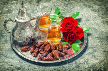 Kırmızı gül çiçekler çay ve tarihleri meyve ile. Ramazan. Vintage arpacık