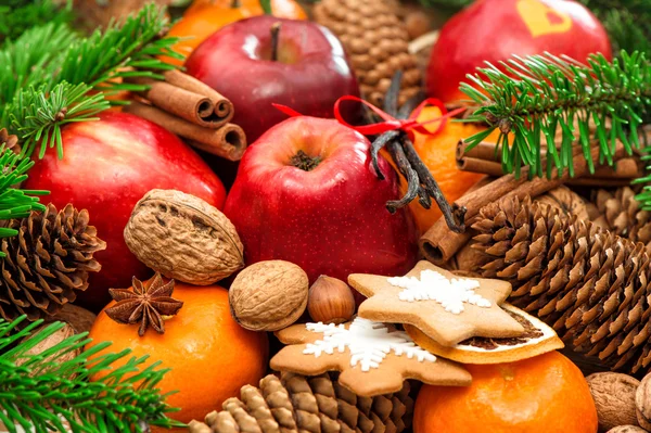 Christmas food background. Apple and mandarin fruits, walnuts, c ȁ Christmas food background. Apple and mandarin fruits, walnuts, c Royalty Free Stock Images