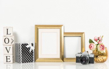 Golden picture frame, rose flowers and vintage camera. Retro sty