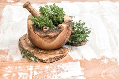 Mortar with thyme sprigs. Olive wood kithchen tools. Herbs and s