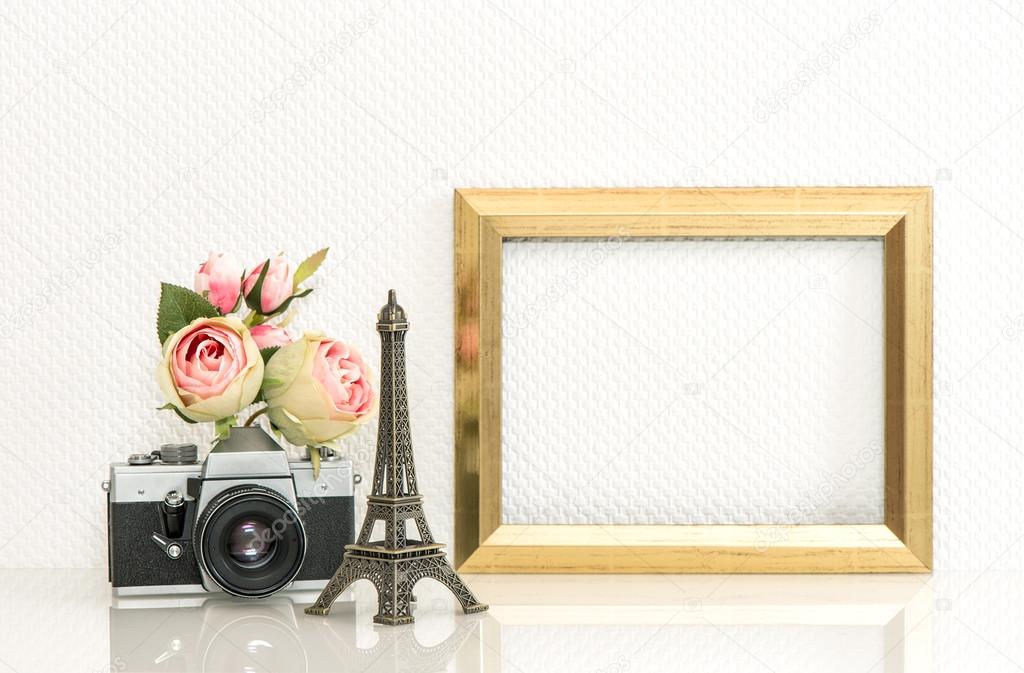 Golden picture frame, rose flowers and vintage camera. Paris tra