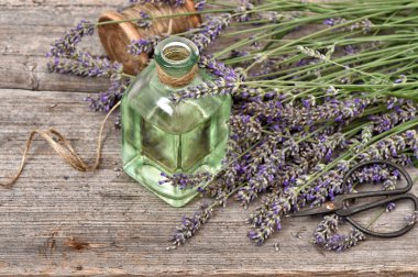 Bitkisel lavanta yağı ile taze çiçekler buket ahşap backgro üzerinde