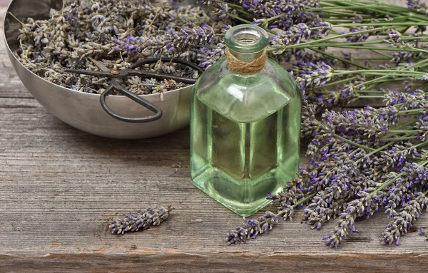 Óleo de lavanda com flores frescas sobre fundo de madeira. Vindima — Fotografia de Stock