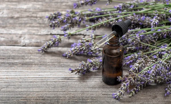 Rostlinné oleje a lavender květiny kytice na dřevěné pozadí — Stock fotografie