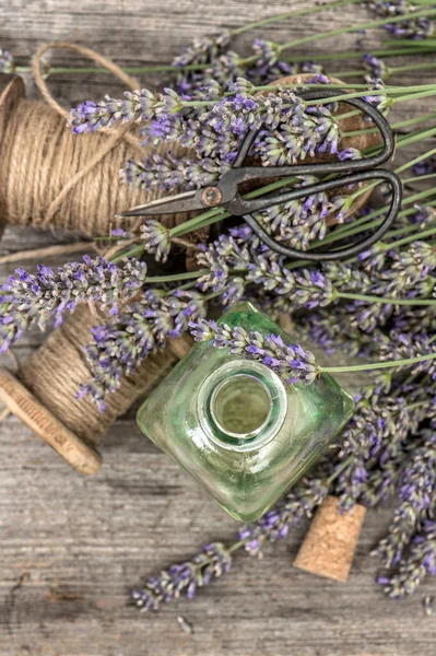 Geparfumeerd kruidenolie essentie en lavender bloemen. Vintage decora — Stockfoto