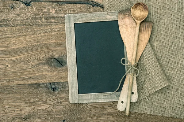 Retro kitchen utensils and vintage blackboard on wooden backgrou — Stock Photo, Image