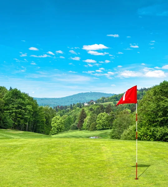 Green golf field and cloudy blue sky — 图库照片