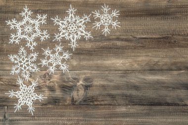 Snowflakes over rustic wooden background. Festive decoration