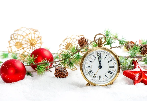 red baubles and antique golden clock in snow on white
