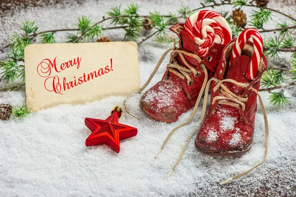 Christmas decoration red stars, sweets and antique baby shoes — Stockfoto