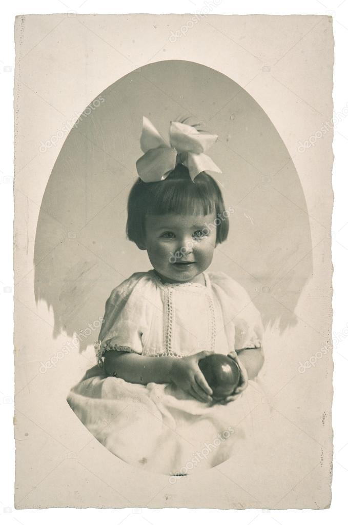 Old family photo portrait of little girl with toy ball