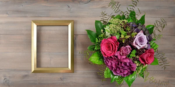 Gouden afbeeldingsframe en roze bloemen. Vintage stijl mockup — Stockfoto