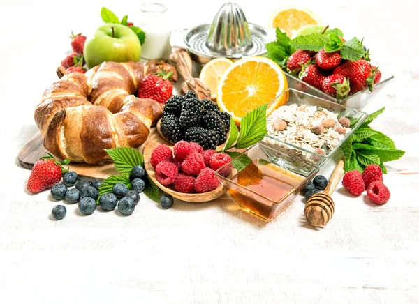 Ontbijt met croissants, verse bessen, muesli en fruit. Gezondheid — Stockfoto