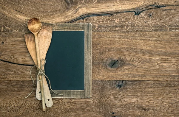 Utensílios de cozinha antigos e quadro-negro em fundo de madeira — Fotografia de Stock