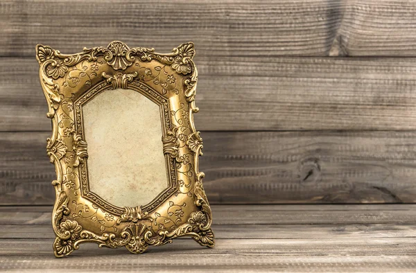 Golden vintage picture frame on wooden background — Stock Photo, Image