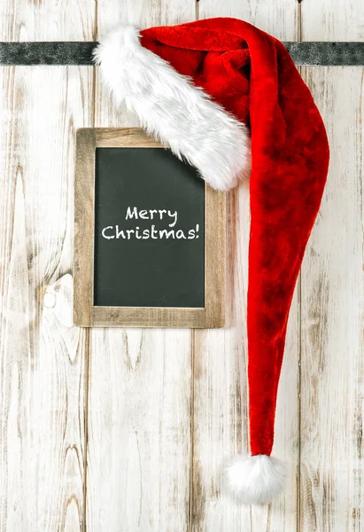 红色圣诞老人的帽子和复古黑板。圣诞快乐 — 图库照片