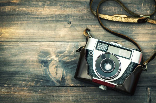 Câmera retro em fundo de madeira rústica. Estilo vintage — Fotografia de Stock