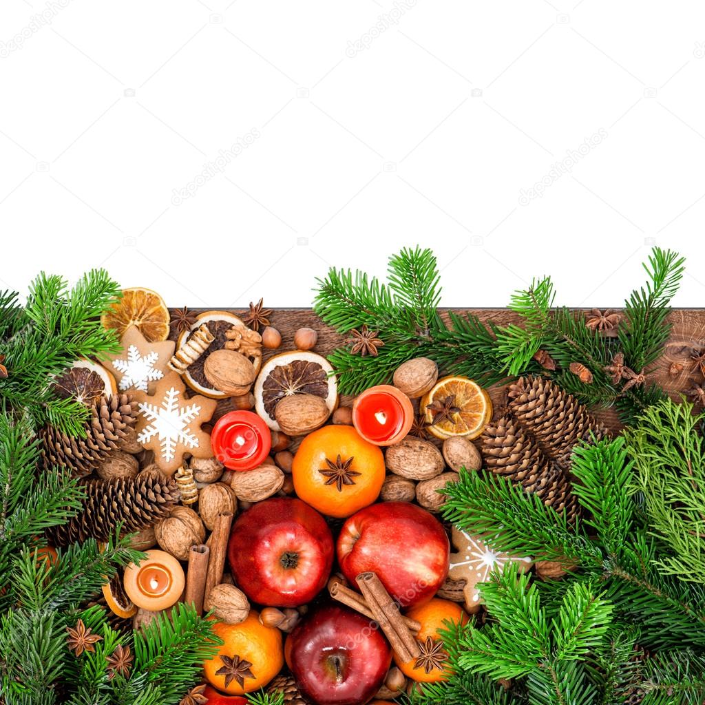Apples, tangerine fruits, cookies and spices with christmas tree