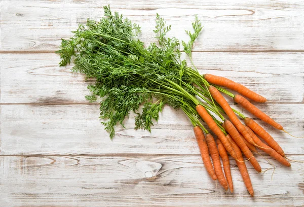 Raíces frescas de zanahorias con hojas verdes. Alimentos ecológicos — Foto de Stock