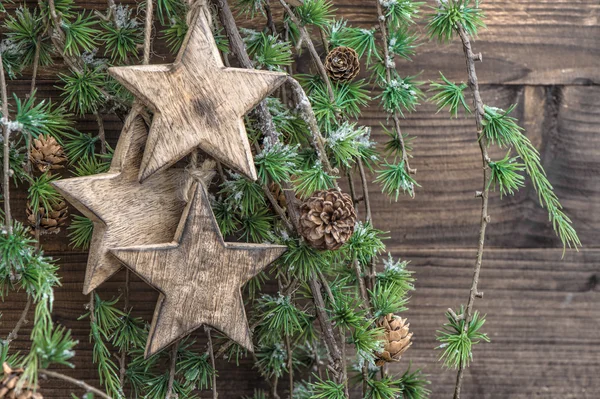 Рождественские украшения деревянные звезды и ветви сосны — стоковое фото