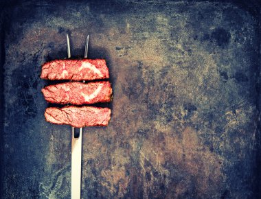 Grilled beef meat on vintage metal background. Food concept