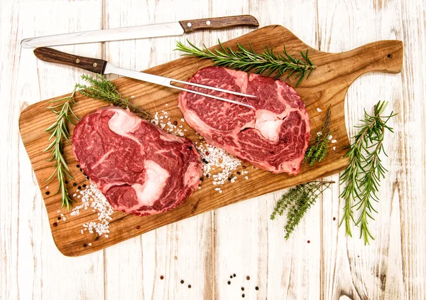 Frisches Fleisch Ribeye Steak mit Kräutern und Gewürzen Lebensmittel-Hintergrund — Stockfoto
