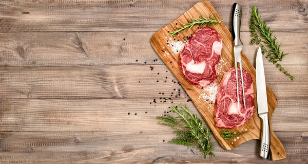 Raw meat Ribeye Steak with herbs and spices — Stock fotografie