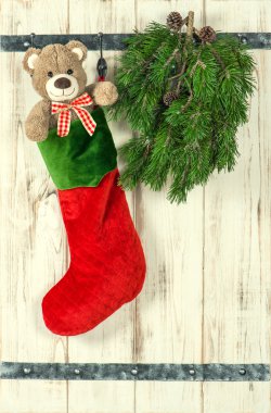 Christmas decoration. Red stocking, Teddy Bear and green pine tr