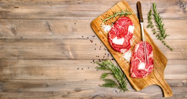Raw beef meat Rib Eye Steak with herbs and spices