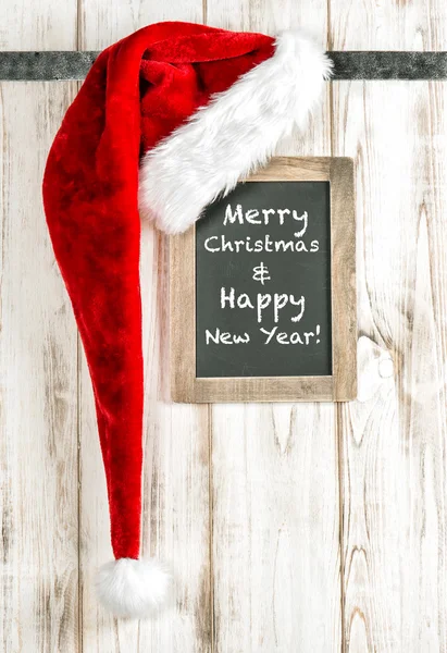 Chapéu vermelho de Papai Noel e chalkboard vintage. Feliz Natal decoração — Fotografia de Stock