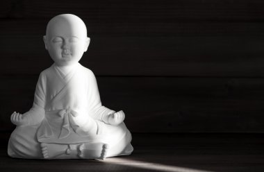 Beyaz keşiş heykeli. Buda oturuyor. Meditasyon ve rahatlatıcı