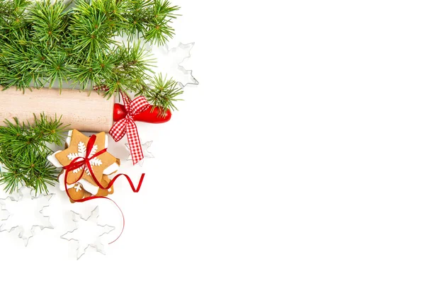 Gingerbread cookies with christmas tree branches over white — Stockfoto