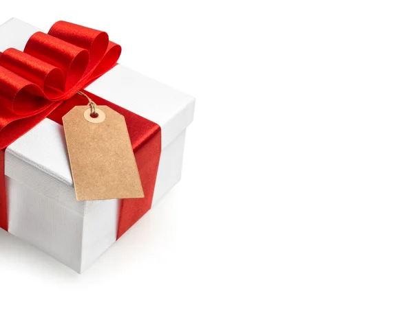 Confezione regalo bianca con fiocco nastro rosso e etichetta isolata su bac bianco — Foto Stock