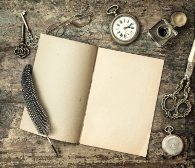 Open book and vintage office supplies feather pen, inkwell