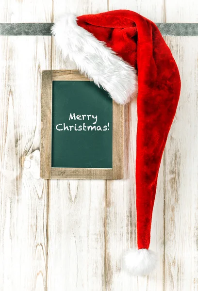 Red hat and vintage chalkboard. Merry Christmas retro style — Zdjęcie stockowe