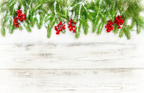 Karácsonyfa sprigs a piros bogyós gyümölcsök. Téli ünnepek dekoráció — Stock Fotó