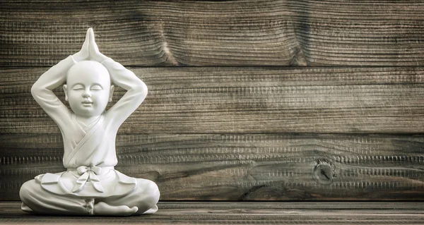 Buda sentada. Estátua de monge branco no fundo de madeira — Fotografia de Stock