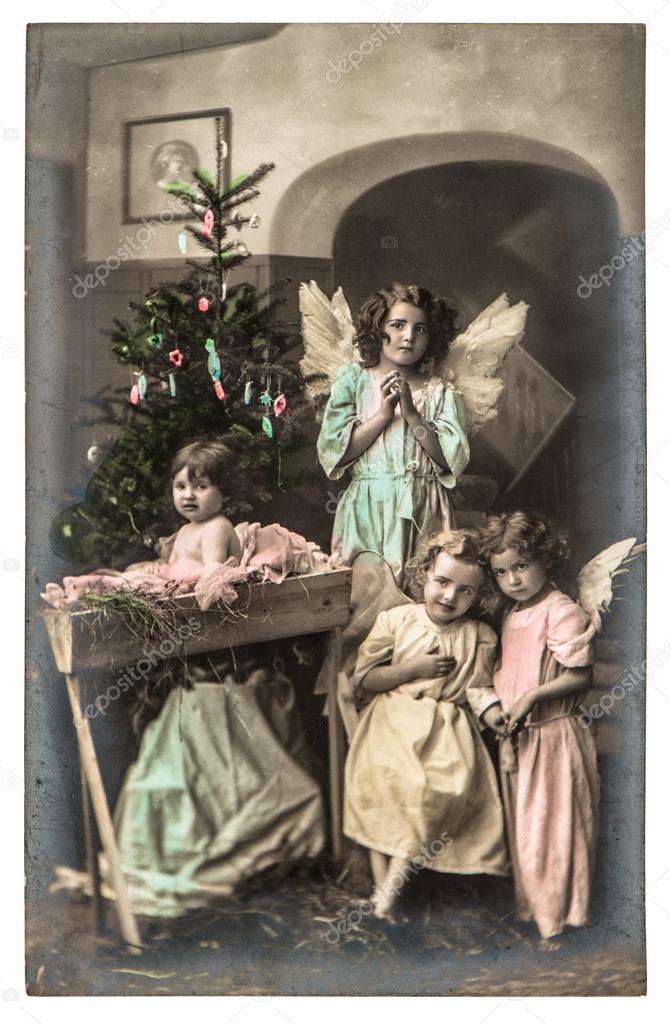 Lovely kids with white angels wings and christmas tree