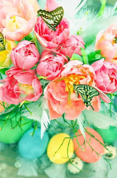 Tulpenblumen, Schmetterlinge und bunte Ostereier — Stockfoto
