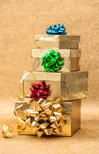 Gouden geschenkdozen met lint buigen glanzende achtergrond — Stockfoto