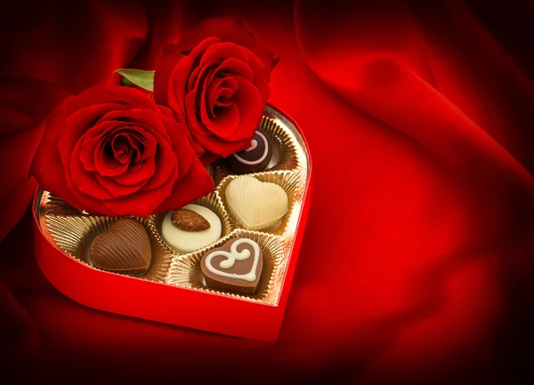 Roses rouges et bonbons au chocolat. Coffret cadeau. Le coeur. L'amour — Photo