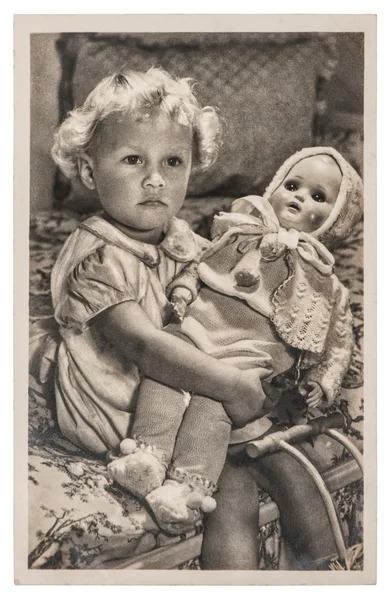 Ragazzina che gioca con una bambola grande. Immagine vintage — Foto Stock