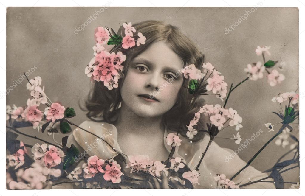 Portrait of little girl with flowers. Vintage picture