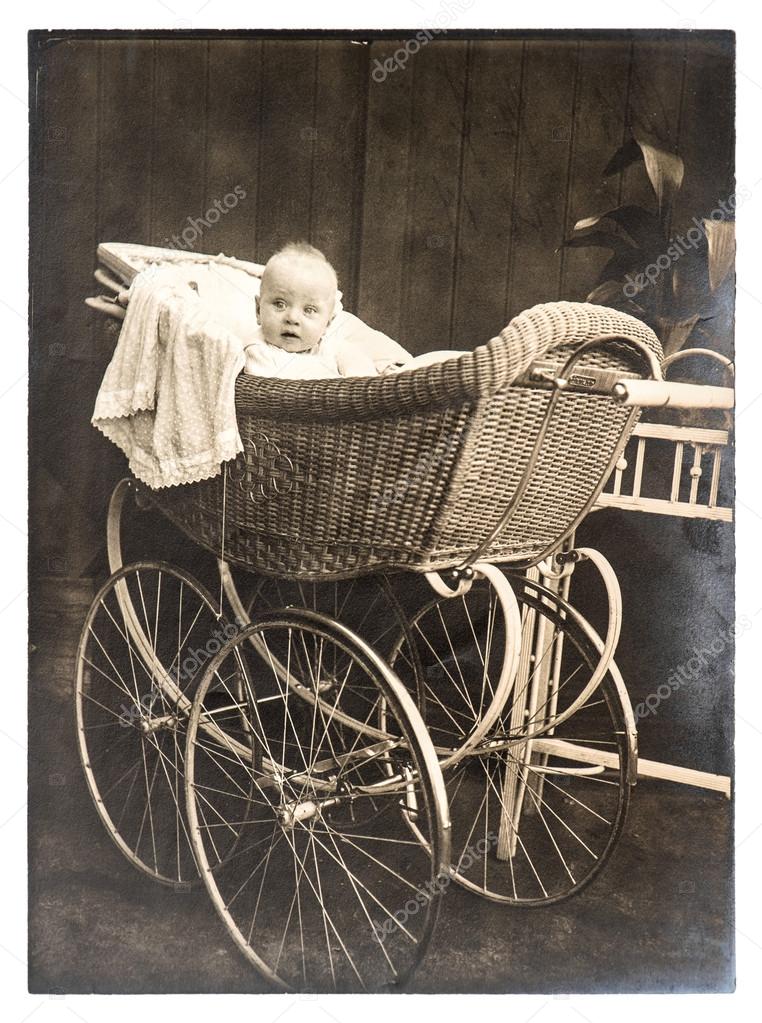 Cute baby in vintage buggy. Vintage picture