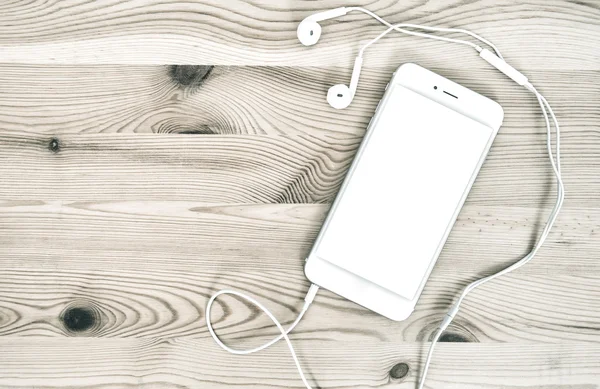Digital telefon hörlurar på trä bakgrund — Stockfoto