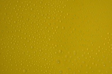 Sarı arkaplan dokusuna doğal su damlaları