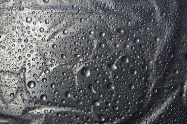 Metal yüzey dokusuna su damlaları. Arka plan parlak metal yüzey.