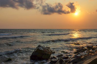 Deniz manzarası gün batımı güneş deniz dalgası deniz köpüğü. Taş sahili. Güzellik doğası. Tatil, yaz.