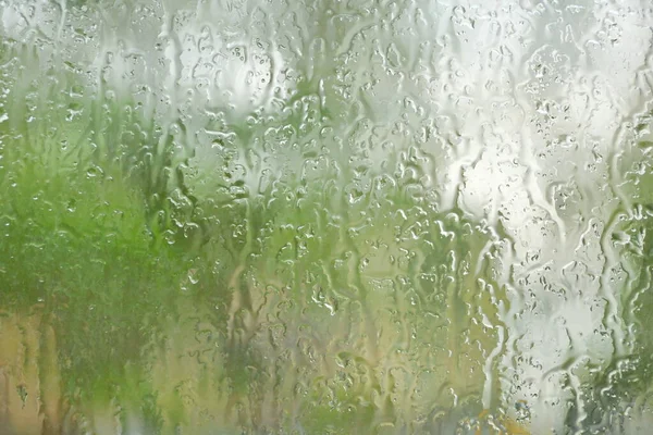 the rain outside the window. rain drops on glass spring or autumn