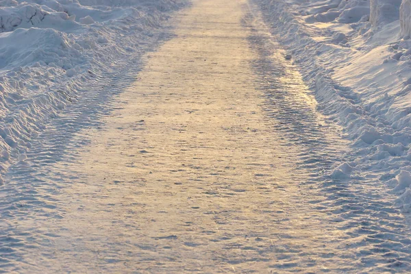 Pokryta Śniegiem Zimowa Droga Oświetlona Zachodzącym Słońcem — Zdjęcie stockowe